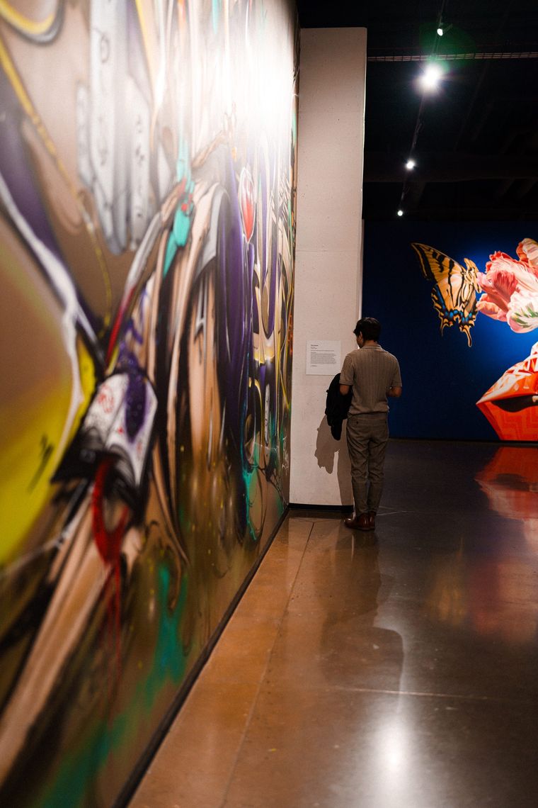 A guest reads the wall label beside The Earwig's wildstyle mural at Walls Within, Hopscotch Portland