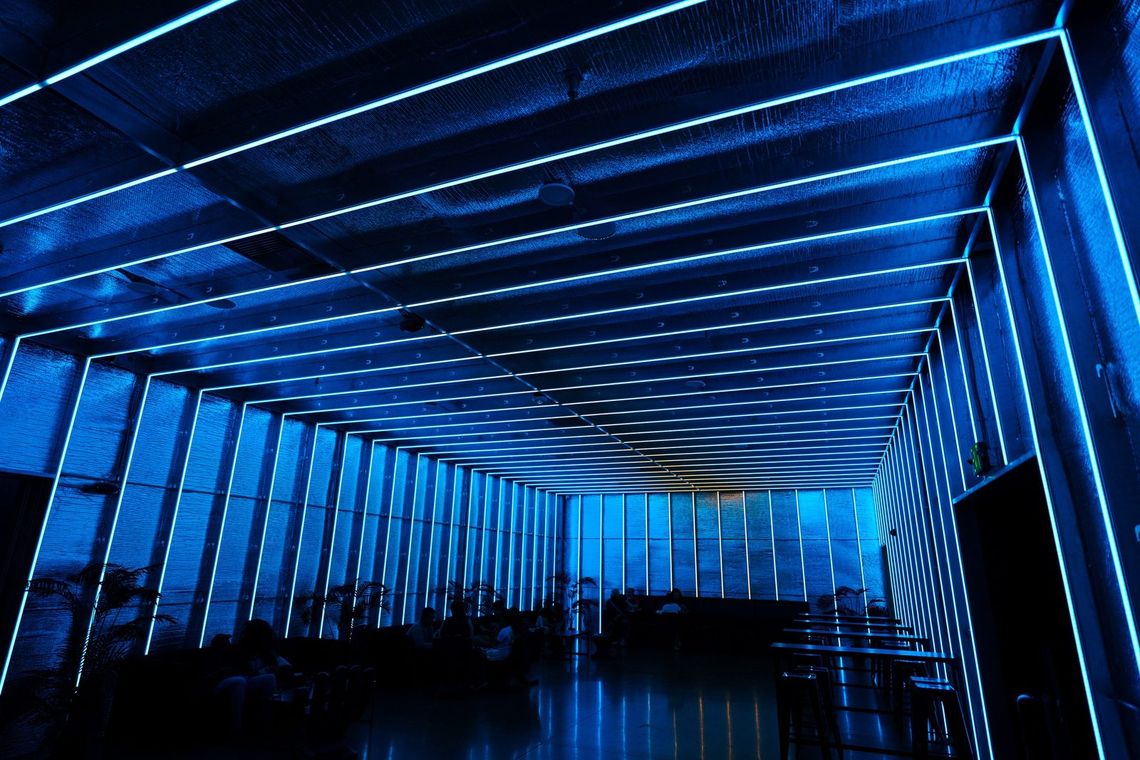 The Portland Lounge in blue, lines of light running the length of the ceiling.