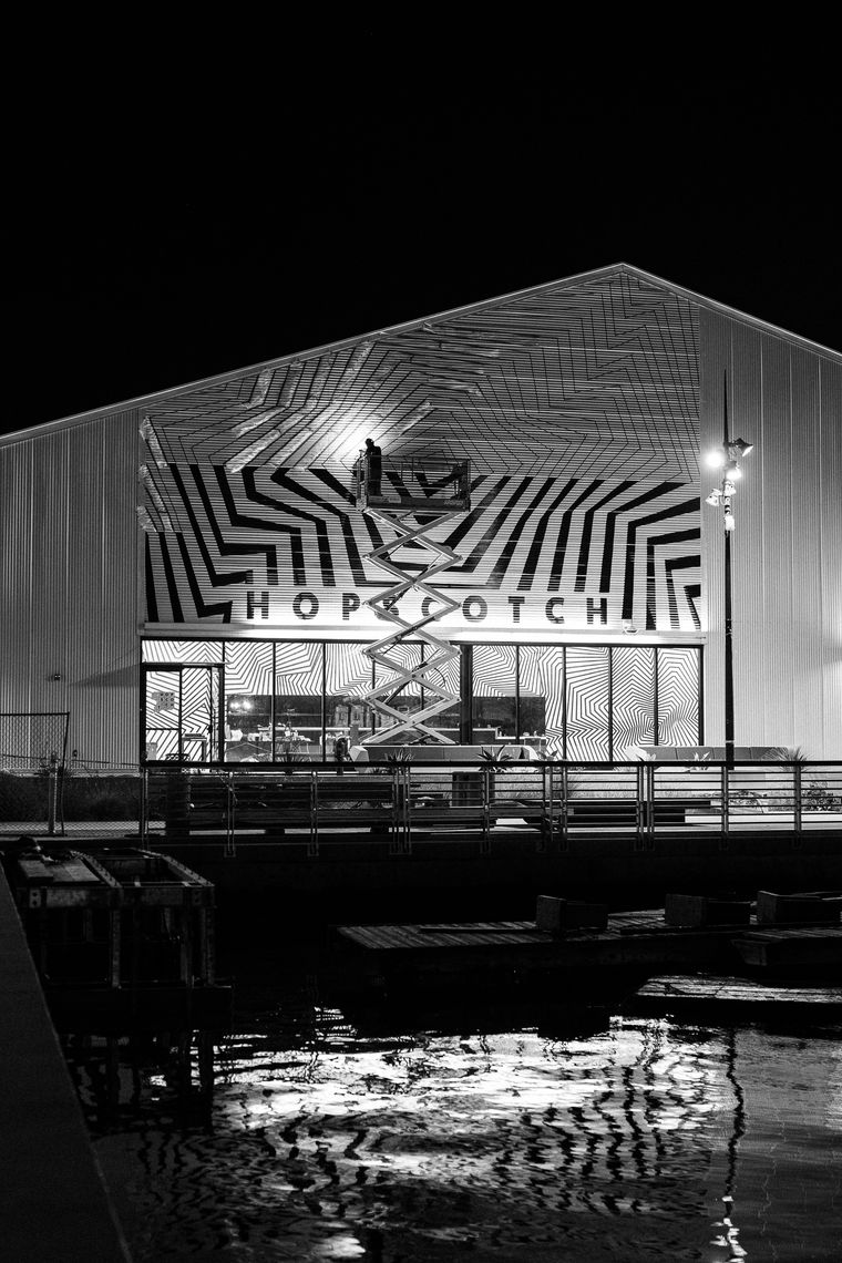 Black-and-white painted lines on the Hopscotch Los Angeles building exterior at night.