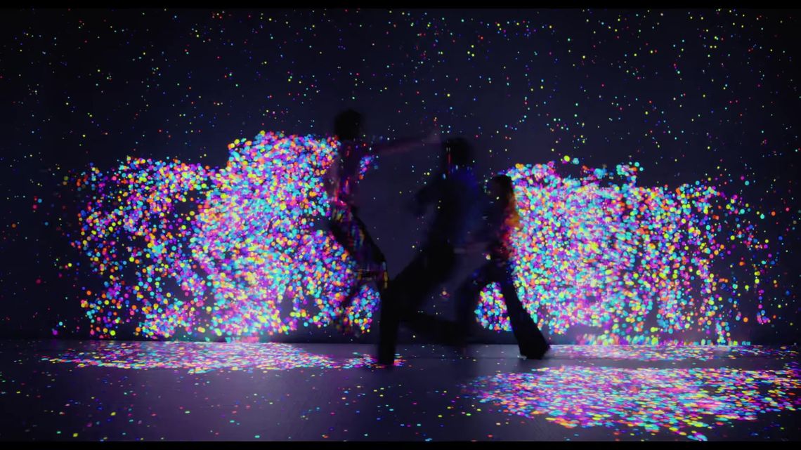 Characters jumping amid colorful particle projections in Quantum Trampoline.