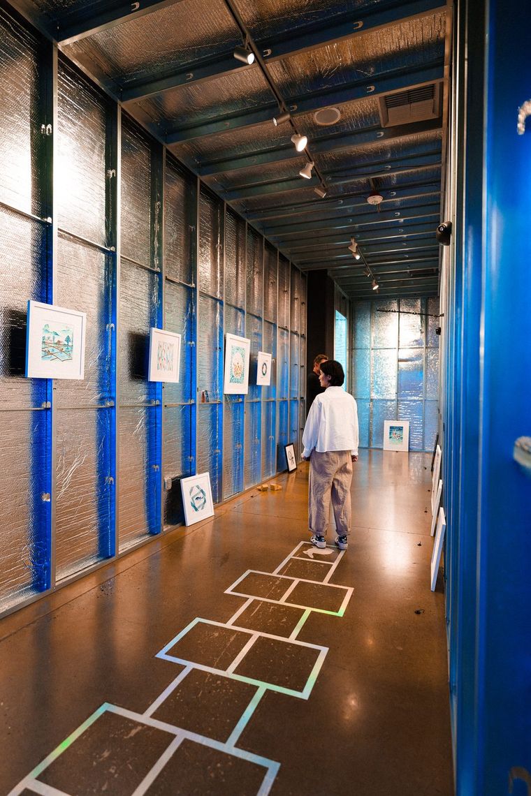 The Ningshu Fang featured gallery in Portland: framed watercolors along a silver hallway, a guest looking at one.