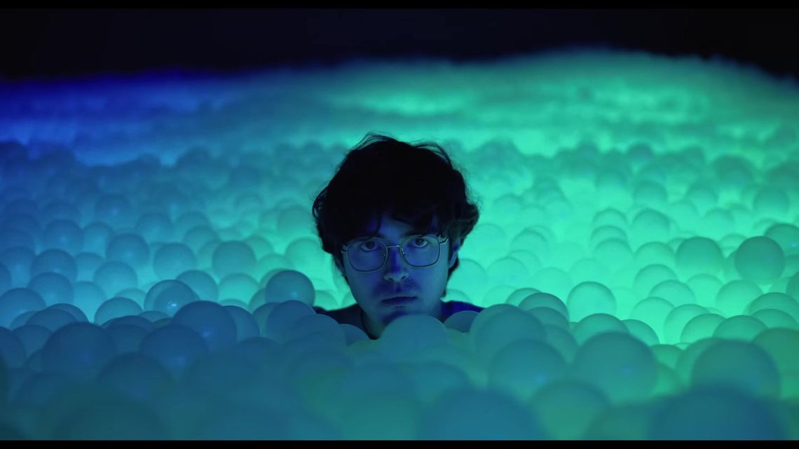 James Sweeney surrounded by turquoise glowing balls in Diodic Daydream.