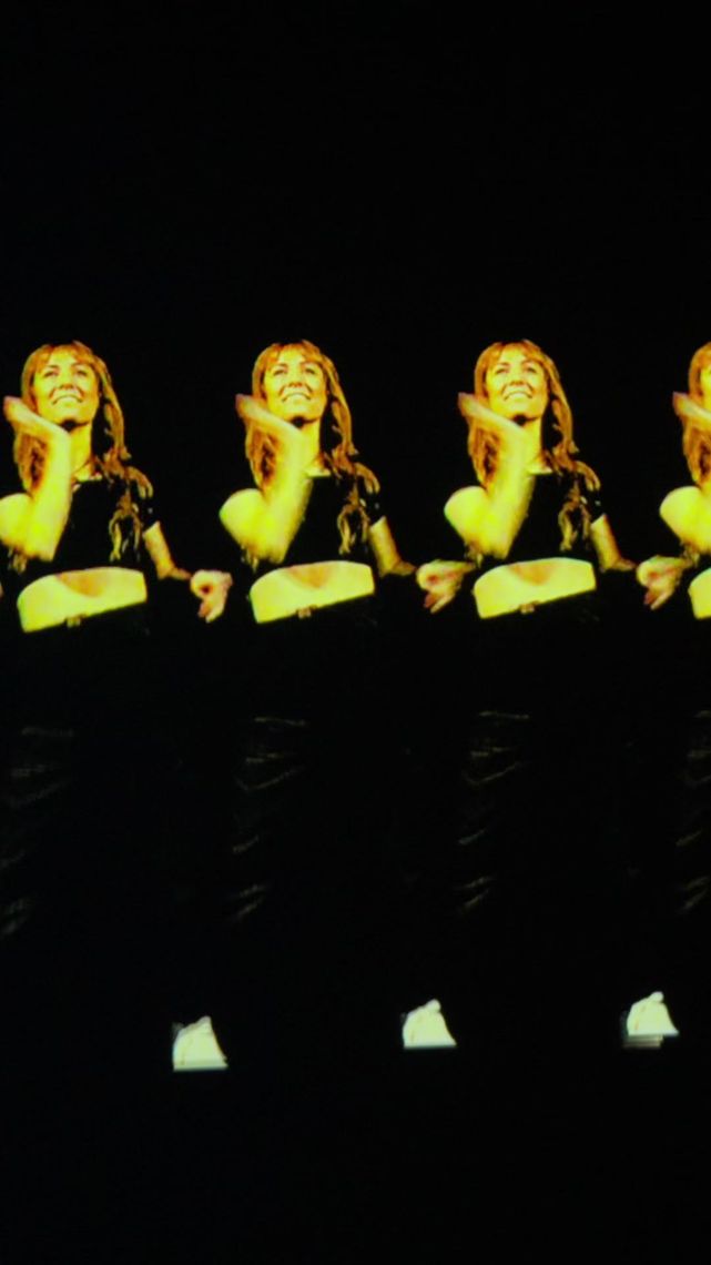 A dancer repeated in a row of gold echoes across a black screen, each copy a beat behind the last.